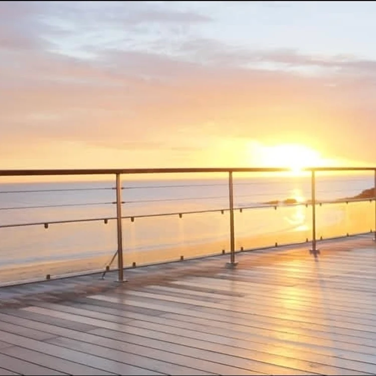 Escalier extérieur — rambarde câble, vue coucher de soleil.