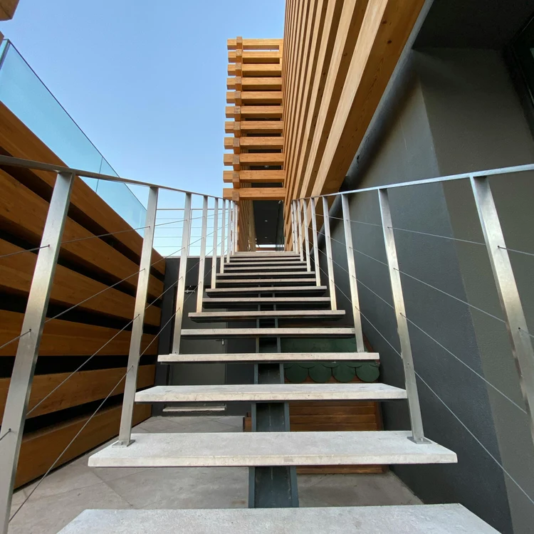 Escalier extérieur contemporain — bardage bois et câble métal.